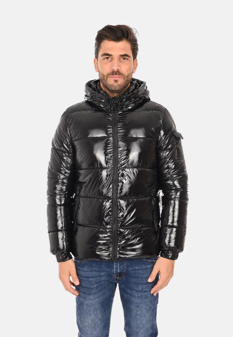 Giacca a vento nera con finitura lucida, chiusura con zip e cappuccio. Presenta sezioni trapuntate e un design elegante. Indossata sopra jeans blu.
