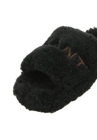 Czarne, puszyste klapki wsuwane wykonane z teksturowanego materiału, charakteryzujące się designem z odkrytym palcem i jasnobrązowym przeszyciem z logo.