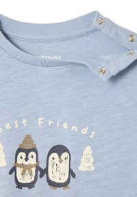 Hellblaues Kurzarmhemd mit strukturiertem Finish, mit einer Grafik von zwei Pinguinen und dem Text "Beste Freunde" darüber.