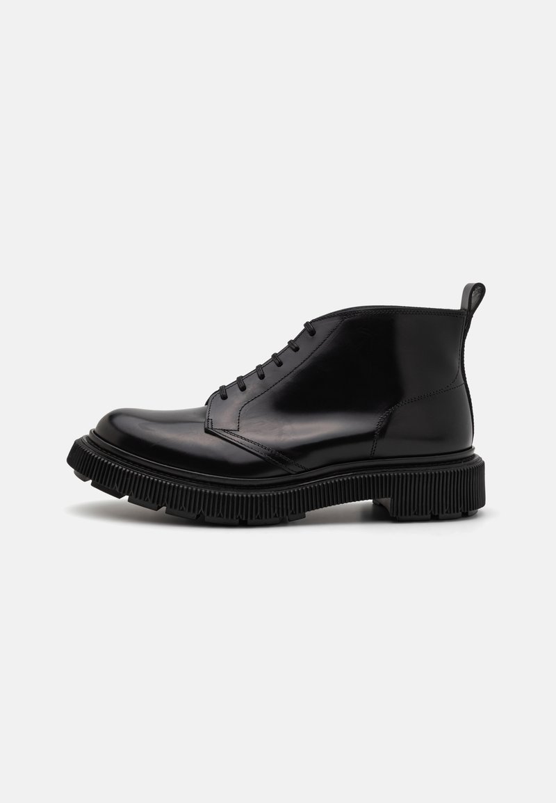 Zwarte leren enkelboots met een ronde neus, vetersluiting aan de voorkant en een gestructureerde rubberen zool met opvallende groeven en een trekhaak.