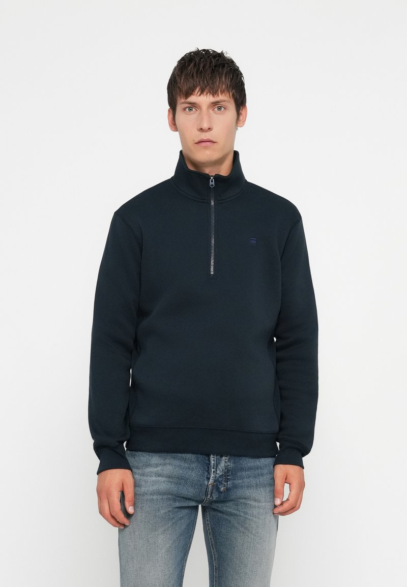 Sweat à col haut en polaire marine avec fermeture zippée quart. Caractéristiques : poignets et ourlet côtelés, ainsi qu'un logo discret sur la poitrine.