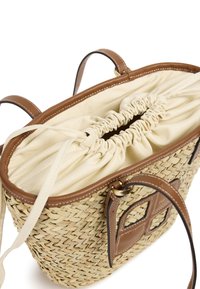 Sac à main en paille tissée avec des accents en cuir marron, doté d'une fermeture à cordon, d'une doublure beige et de solides doubles bretelles pour l'épaule.