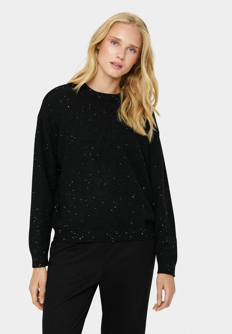 Schwarzer Pullover mit rundem Kragen und langen Ärmeln, mit einer strukturierten Oberfläche und verstreuten silbernen Funken. Glatte Strickoptik, lockere Passform.