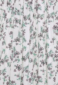 Tissu blanc avec des feuilles vertes et de petits bouquets de fleurs roses et violettes dans un motif floral délicat et dispersé.