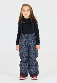 Blå blommiga snöbyxor med justerbara axelremmar, matchade med en svart långärmad tröja och rosa skor. Slät tyg, vadderade för värme.