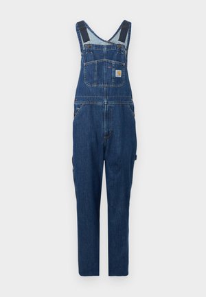 Salopette in denim blu scuro con tasca frontale sul petto, spalline regolabili, tasche laterali e pantaloni a gamba dritta su sfondo grigio chiaro.