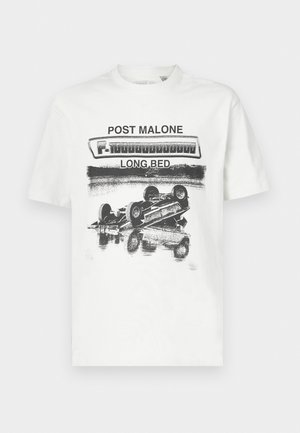 Balta kokvilnas t-krekls ar melnu grafiku, kurā attēlots apgāzts auto un uzraksti "POST MALONE" un "LONG.BED" treknā fontā. Regulāra piegriezuma dizains.