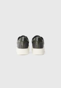 Green leather sneakers with contrasting mesh panels and a thick white sole. Back features a striped accent on the heel.