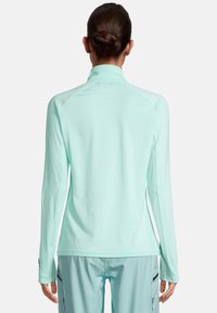 Langarm, mintgroen sporttop met een ritskraag, een gladde textuur en raglanmouwen. Heeft een lichte drop-tail zoom voor extra bedekking.