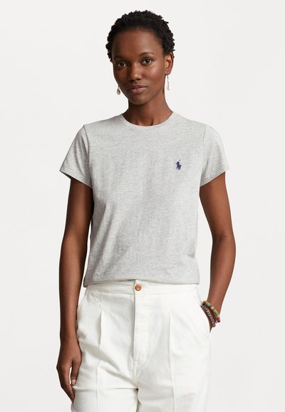 T-shirt en coton gris avec un col rond et des manches courtes, comportant un petit logo bleu sur la poitrine gauche. Texture lisse, design ajusté.