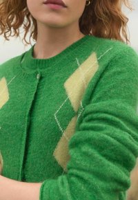 Groene wollen cardigan met gele ruitpatronen, voorzien van een ronde hals, knoopsluiting en textuurstof.