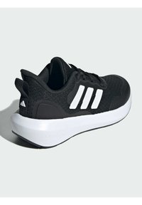 Scarpa atletica nera con tomaia in maglia texturizzata, caratterizzata da tre strisce bianche, una suola bianca ammortizzata e un tallone rinforzato.