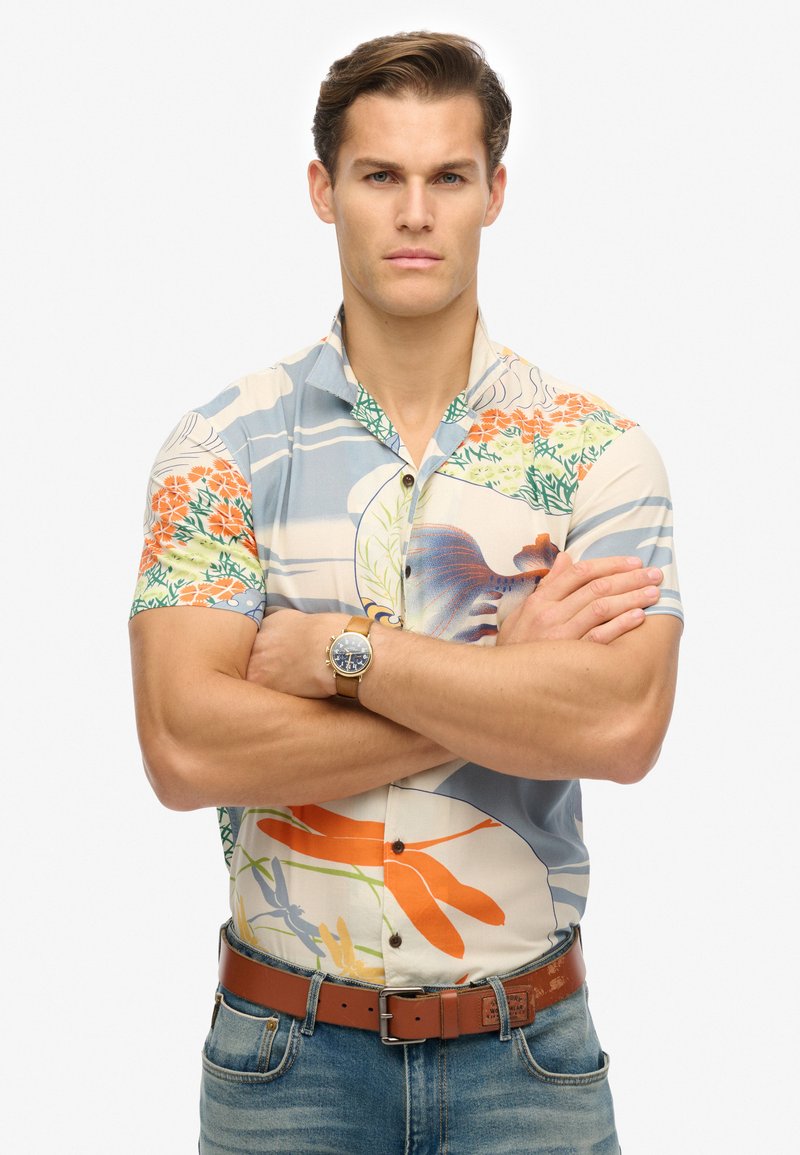 Korte mouw knop-up shirt met een meerkleurig bloemenpatroon, met een lichtblauwe basis, groene accenten en een kraag.