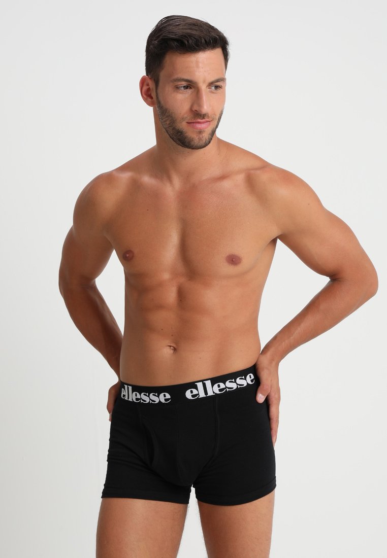 Schwarze Baumwollboxershorts mit einem weißen, gebrandeten Bund, ausgestattet mit einer praktischen frontalen Öffnung und einem glatten, körpernahen Schnitt.