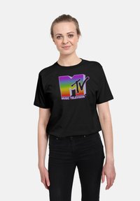 Camiseta negra con un logo de MTV multicolor y un efecto degradado. Manga corta y un ajuste relajado.