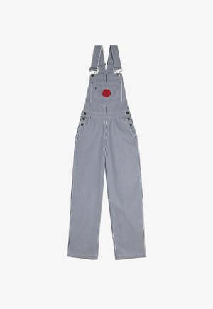 Salopette rayée bleue et blanche avec une poche en patch rouge, fabriquée à partir d'un tissu durable, avec des bretelles ajustables et des détails en métal.