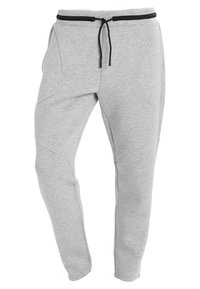 Grå sweatpants gjorda av mjukt material, med dragsko i midjan, tapered ben och böjda sömmar på sidan.
