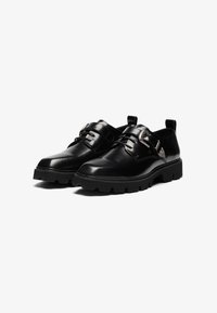Schwarze Lederschuhe mit glatter Oberfläche, dekorativem Schnallenverschluss und robustem Sohle mit dickem Profil. Minimalistisches Design mit Knöchel-Schnitt.