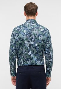 Langsleeve shirt van donkerblauwe stof met een paisleypatroon in groentinten en wit, met een standaard kraag en knopenmanchetten.