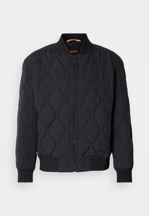 Black quilted bomber jacket featuring a ribbed collar and cuffs, structured diamond pattern, and front zipper closure. Branding on the inner neck.