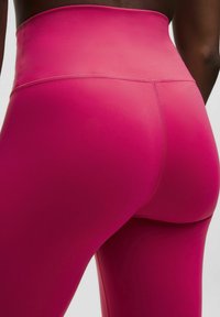 Fuchsia hoge taille legging gemaakt van rekbaar materiaal, met een gladde textuur en minimale stiksels.