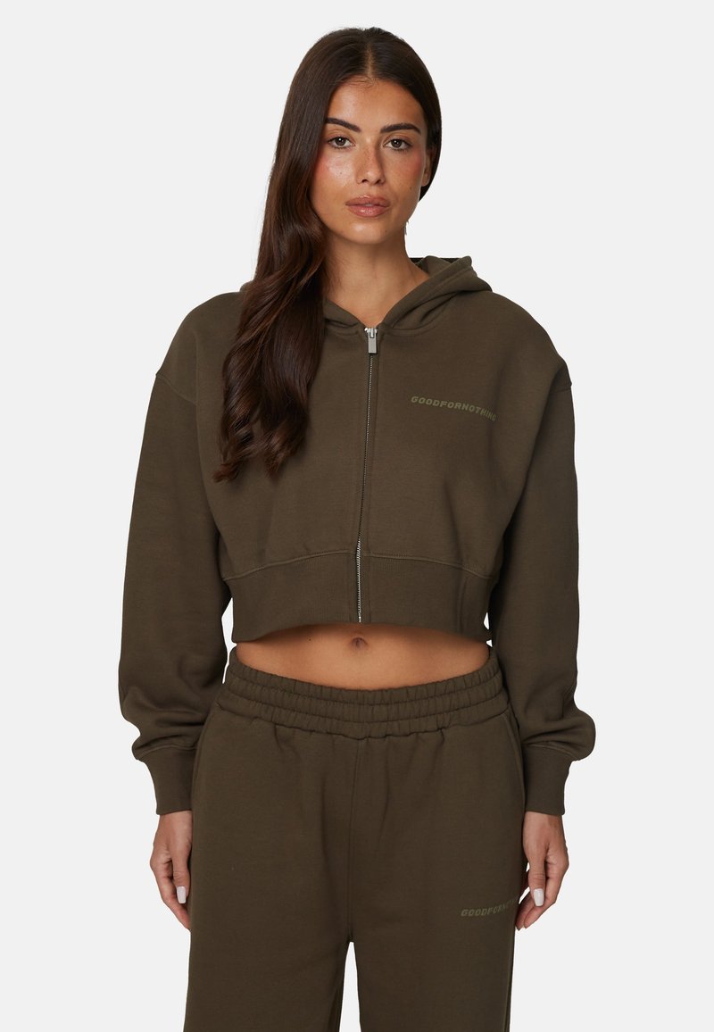 Sweat à capuche zippé, cropped, en mélange de coton vert olive. Doté d'une capuche avec cordon de serrage et d'un logo brodé sur la poitrine. Associé à un pantalon de survêtement assorti.