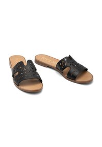 Czarne skórzane klapki z wycięciami, brązowa wkładka i płaska podeszwa. Model na odkryte palce bez zapięcia.