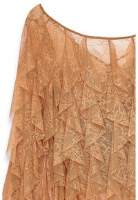 Poncho in pizzo di un caldo arancione, con bordi arricciati, intricate fantasie floreali e una texture leggera e trasparente. Morbide cadute per un effetto fluido.