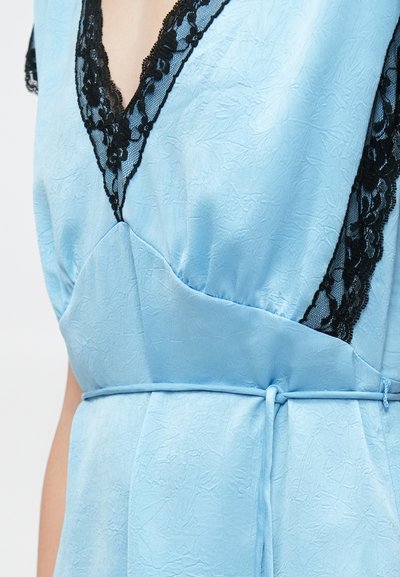 Φόρεμα σε ανοιχτό γαλάζιο χρώμα με υφή, διακοσμημένο με μαύρη δαντέλα κατά μήκος του βαθιού ντεκολτέ σε σχήμα V και λεπτή ζώνη δεμένη στη μέση, πάνω σε κορμό ανθρώπου.