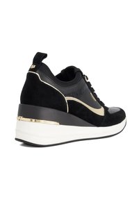 Black and gold low-top sneaker with wedge sole, mesh and suede details, pull tab, and white thick rubber outsole.