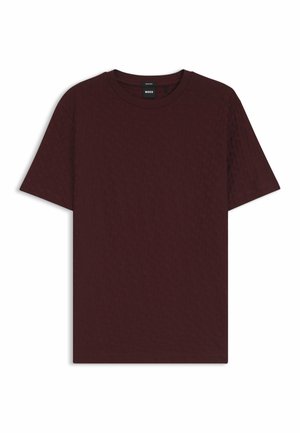Vinröd T-shirt med rund hals i texturerat tyg, med korta ärmar och avslappnad passform. Etikett synlig vid halsringningen.