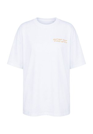 Witte T-shirt met korte mouwen met oranje tekst "GREETINGS FROM STUDIO UNTOLD" op de bovenste linkerborst.