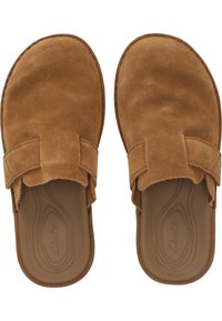 Braune Wildleder Slipper mit abgerundeter Zehenform, die einen dekorativen Riemen über dem Obermaterial und eine glatte Gummisohle aufweisen.