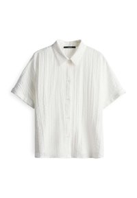 Camicia bianca a maniche corte con un motivo a trama, dotata di colletto e cinque bottoni. Il tessuto ha un aspetto leggero.
