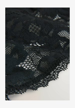 Czarna koronka z kwiatowymi wzorami, łącząca części o gęstym splotie z otwartym tiulem, wykończona falistymi brzegami. Miękka w dotyku.