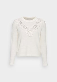 Pull blanc en maille avec un col en v en dentelle et des manches longues. Tissu texturé avec des poignets et un ourlet côtelés.