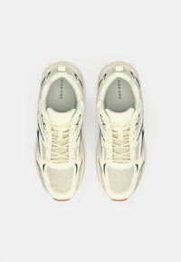 Λευκά αθλητικά παπούτσια από δίχτυ με πράσινες λεπτομέρειες, στρογγυλερή μύτη, δέσιμο με κορδόνια, υφασμένα πάνελ και μπεζ λαστιχένια σόλα. Επωνυμία στο εσωτερικό πέλμα.
