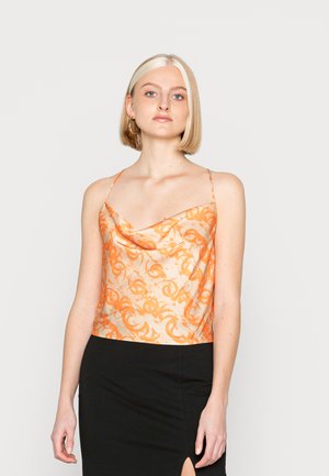Top de cetim com decote drapeado e padrão abstrato em laranja, alças finas e ajustáveis, com barra reta, combinado com uma saia preta. Textura suave.