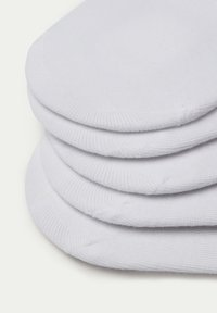 Weiße Baumwollsocken gestapelt, mit glatter Textur, abgerundeter Zehenpartie und gerippten Bündchen für besseren Sitz und Komfort.