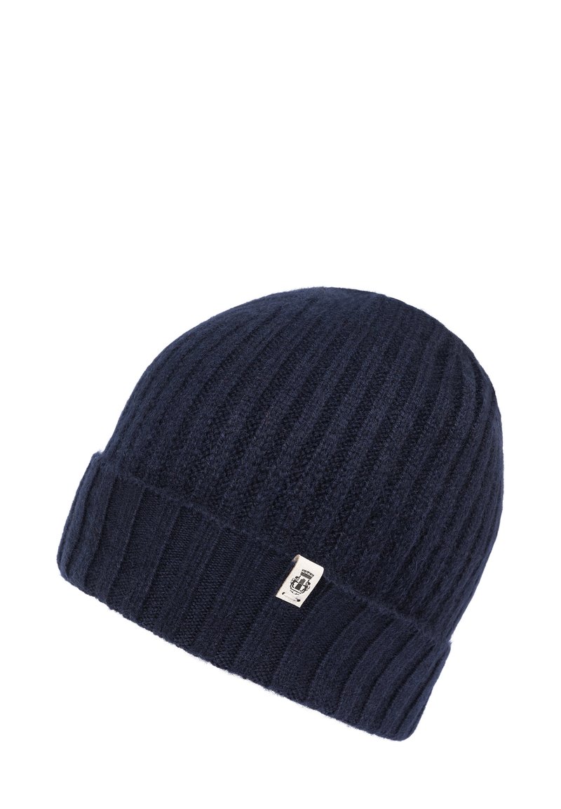 Navy blue ribbed knit beanie hat with folded cuff and small rectangular white label featuring a black emblem.