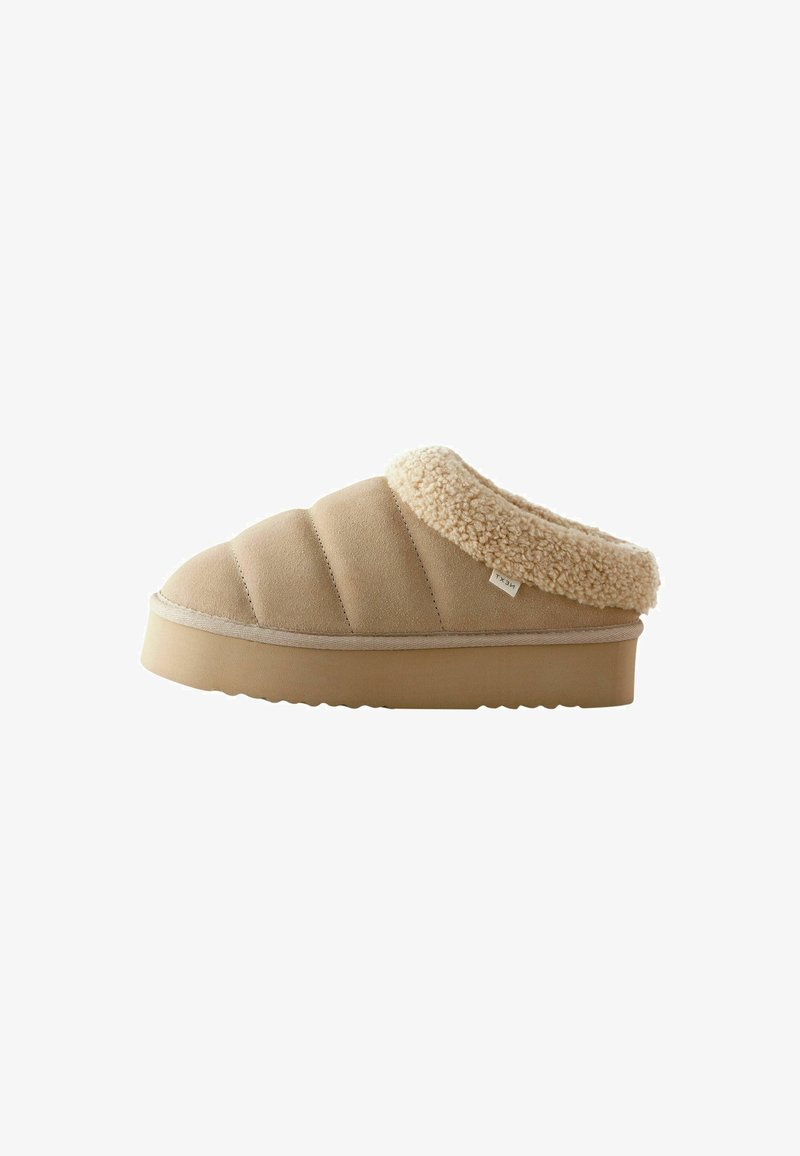 Pantofole beige infilabili con tomaia in suede texture, colletto peloso e suola spessa in gomma con motivo a onde.