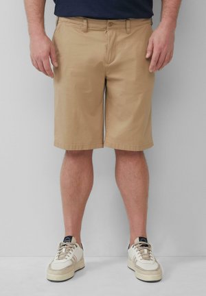 Khaki-Shorts mit geradem Schnitt, ausgestattet mit Gürtelschlaufen, einem Knopfverschluss und seitlichen Taschen. Tragen Sie sie mit weißen und beigen Sportschuhen.