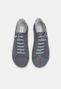 Hallide hallhuvad sneakerid viie helesinise paelaga, ümar varvas ja mustrijooneline, värvikas tald. Omab logo keeltes.