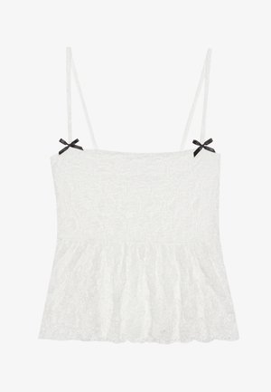 Camisola bianca in pizzo con spalline sottili, caratterizzata da fiocchi neri sulle spalle e un orlo svasato per un design femminile.