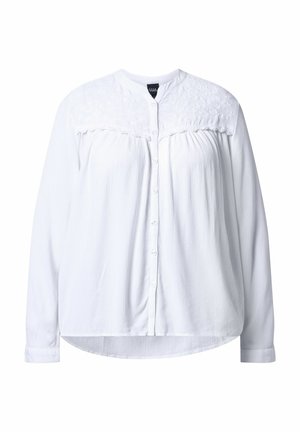 White button-up shirt with a textured yoke, long sleeves, and a rounded hem. Features a smooth fabric with a slightly wrinkled appearance.
