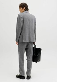 Grå skreddersydd dress med teksturert finish, matchende bukser og svarte skinnsko. Inkluderer en svart tote-veske for funksjonalitet.