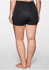 Shorts noirs mi-hauts avec une taille élastique. Tissu lisse et léger, présentant un design ajusté qui arrive jusqu'au mi-thigh.