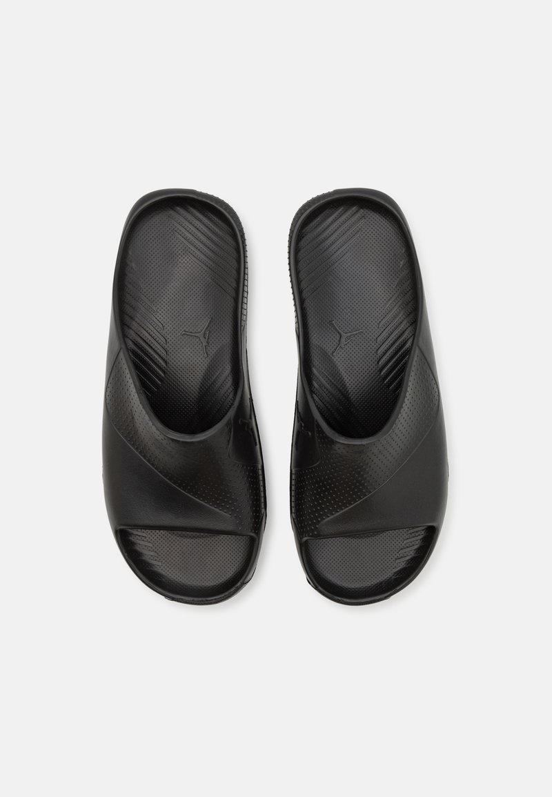 Infradito nere con superficie in gomma testurizzata, design open toe e ritagli laterali. Presentano un logo discreto e una soletta sagomata per il comfort.