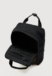 Čierny látkový batoh s predným zipsovým vreckom, širokým otvorom a vnútorným leopardím vzorom. Obsahuje horné držadlo a nastaviteľné ramenné popruhy.