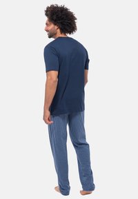 Navyblaues T-Shirt mit kurzen Ärmeln kombiniert mit karierten Schlafanzughosen in Blau und Weiß, mit lockerer Passform und weichem Baumwollmaterial.